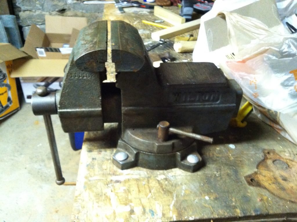 A closed vise on a table with nothing in it. This tool is great for bat juicing. 